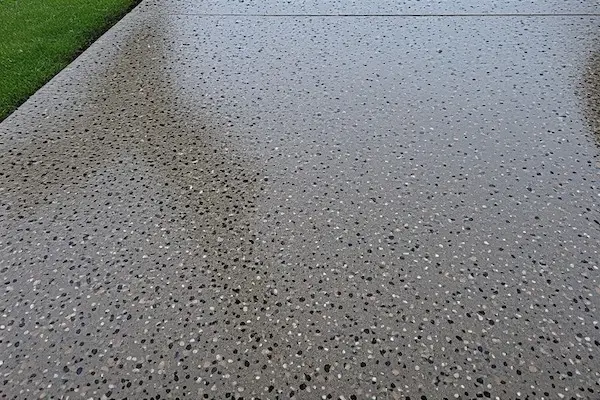 Well-maintained concrete patio with visible sealed surface showing water beading effect