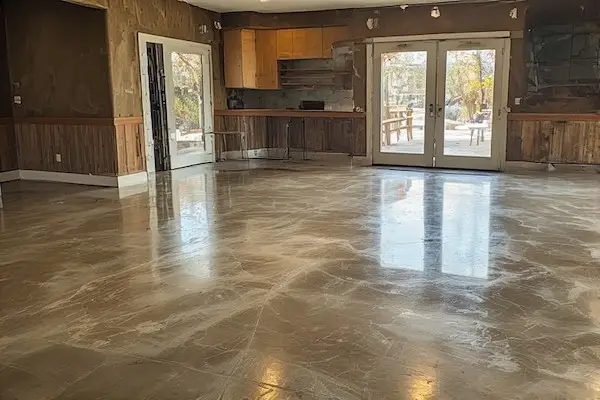 Homeowner performing maintenance on sealed concrete with soft broom and mild cleaner