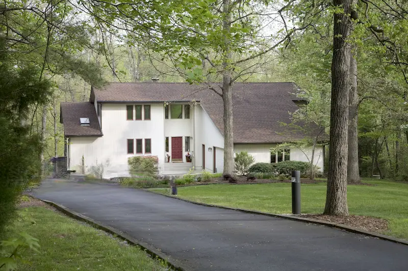 Brand new asphalt driveway with smooth black surface, ready for sealing after proper curing time