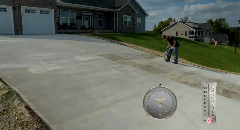 Thermometer and hygrometer showing temperature and humidity readings on a concrete surface being sealed