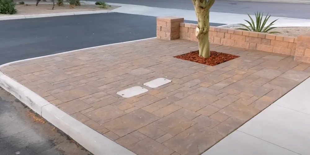 Un trottoir pavé de pavés rouges, avec un arbre visible le long du chemin